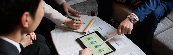 business advisory consultant discuss about Feasibility Study reports with the help of pen, paper and Tablet